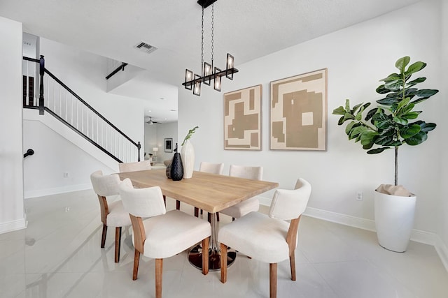 dining space featuring a textured ceiling and light tile patterned flooring