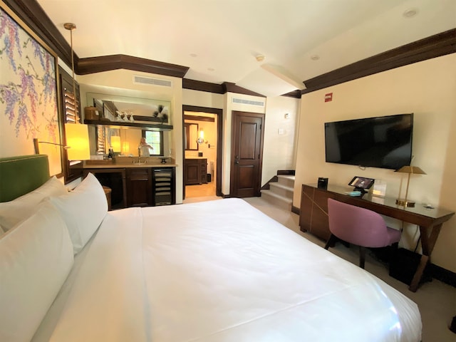 bedroom featuring sink, beverage cooler, and ensuite bath