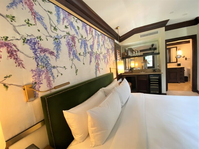 bedroom featuring lofted ceiling, crown molding, and wine cooler