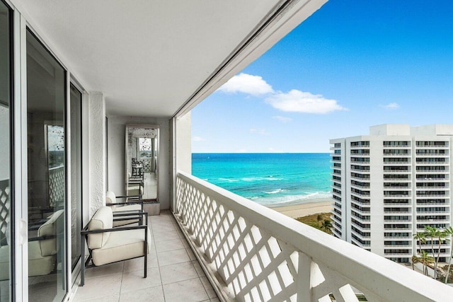 balcony with a water view and a view of the beach