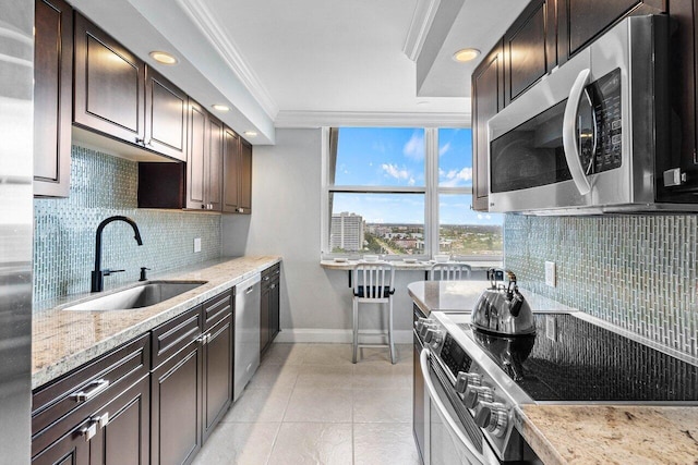 kitchen with sink, crown molding, light tile patterned flooring, light stone countertops, and appliances with stainless steel finishes