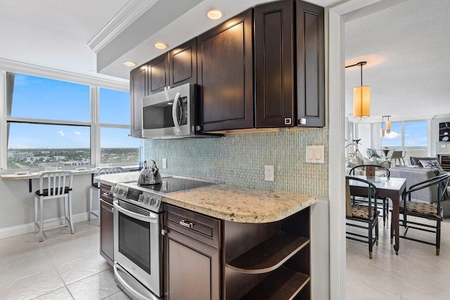 kitchen featuring decorative light fixtures, dark brown cabinetry, ornamental molding, stainless steel appliances, and light tile patterned floors