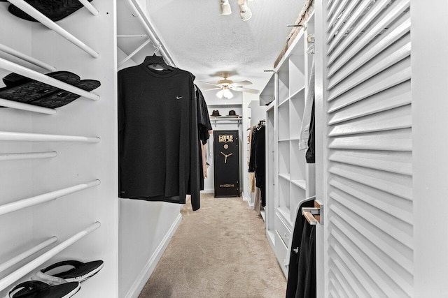 spacious closet featuring ceiling fan and light colored carpet