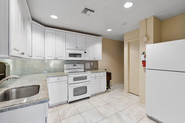 kitchen featuring white cabinets, light stone countertops, sink, and white appliances