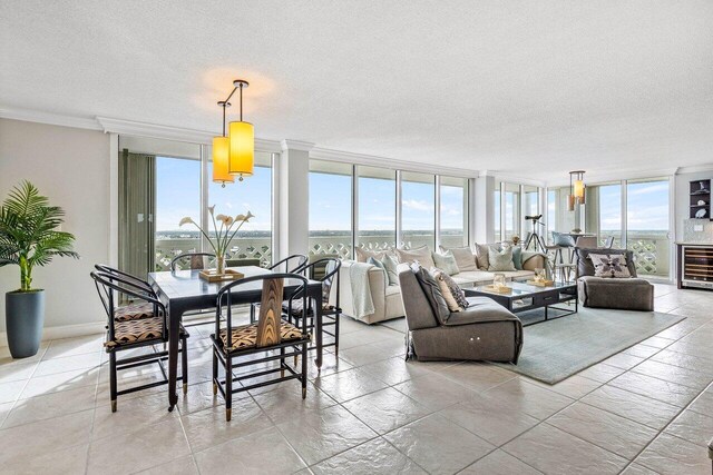 dining space featuring floor to ceiling windows, a notable chandelier, wine cooler, a textured ceiling, and ornamental molding