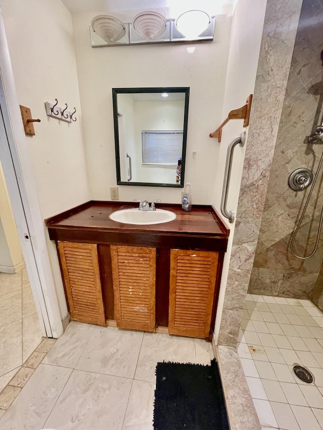 bathroom featuring a tile shower, vanity, and tile patterned floors