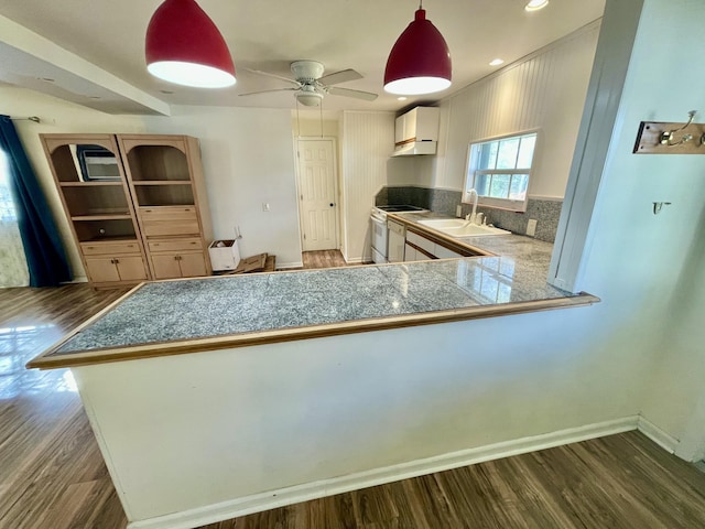 kitchen featuring sink, dark hardwood / wood-style flooring, kitchen peninsula, white range with electric cooktop, and decorative backsplash