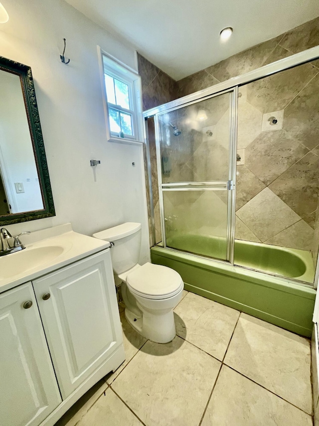 full bathroom featuring tile patterned floors, vanity, toilet, and enclosed tub / shower combo