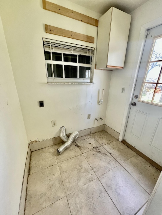 washroom featuring cabinets, light tile patterned floors, and electric dryer hookup