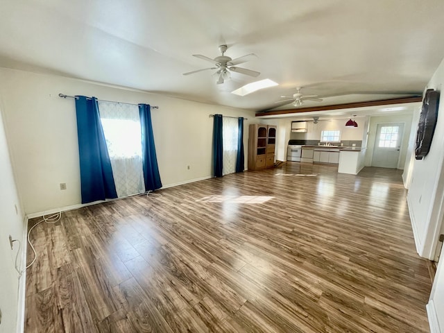 unfurnished living room with hardwood / wood-style flooring, ceiling fan, sink, and a skylight