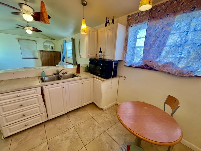 kitchen with sink, light tile patterned floors, pendant lighting, lofted ceiling, and white cabinets