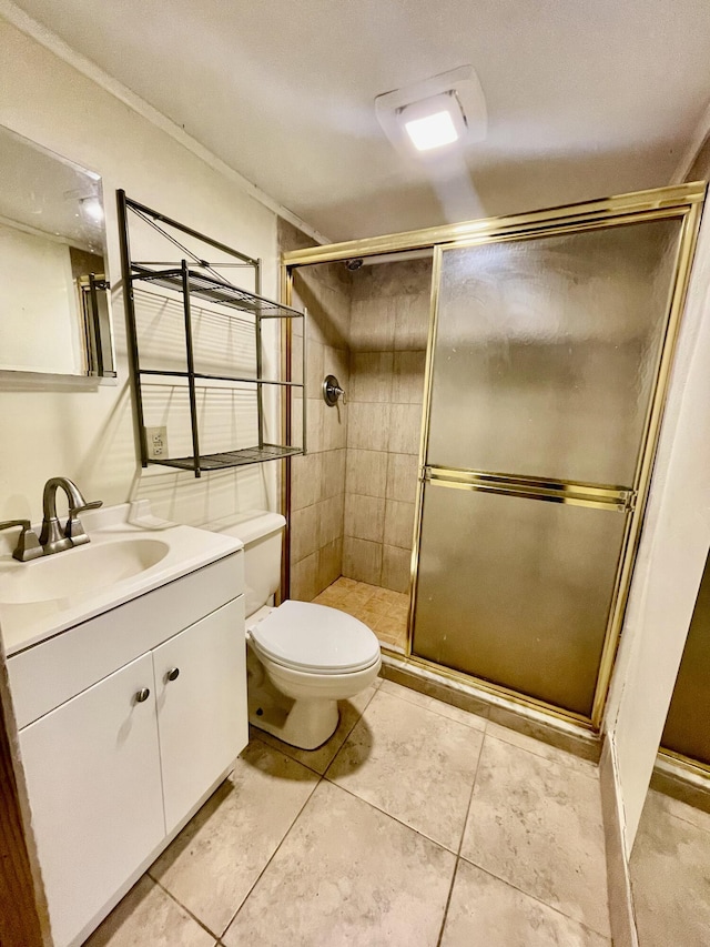 bathroom with tile patterned floors, toilet, vanity, and walk in shower