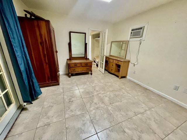 bedroom featuring an AC wall unit and french doors