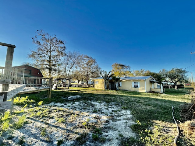 view of yard featuring a sunroom and a wooden deck