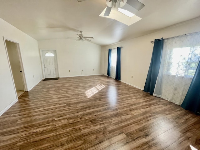 unfurnished living room with wood-type flooring, ceiling fan, and vaulted ceiling with skylight