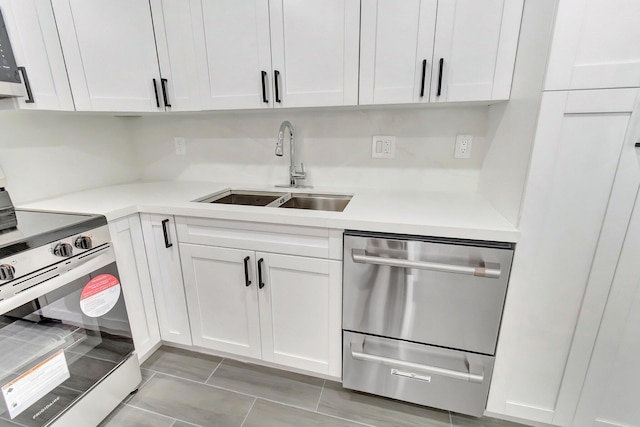 kitchen with white cabinetry, a sink, light countertops, and appliances with stainless steel finishes