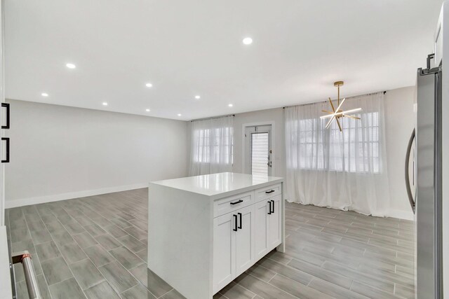 kitchen with white cabinets, light countertops, baseboards, recessed lighting, and freestanding refrigerator
