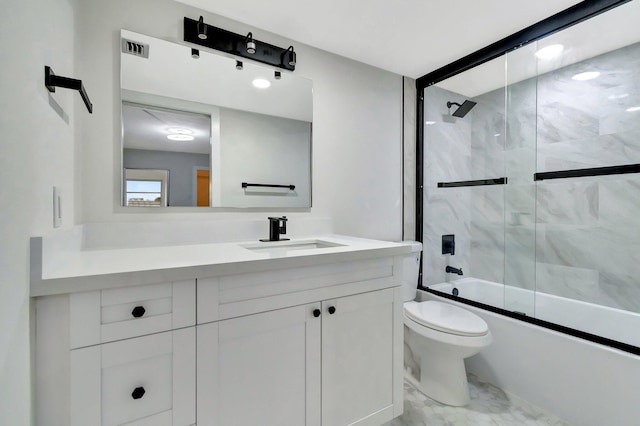 full bath featuring marble finish floor, toilet, bath / shower combo with glass door, and vanity