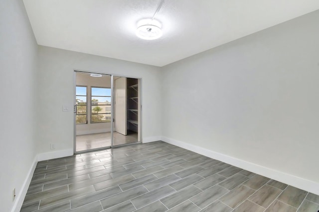 spare room with baseboards and wood tiled floor