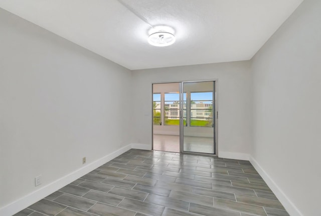 unfurnished room with baseboards