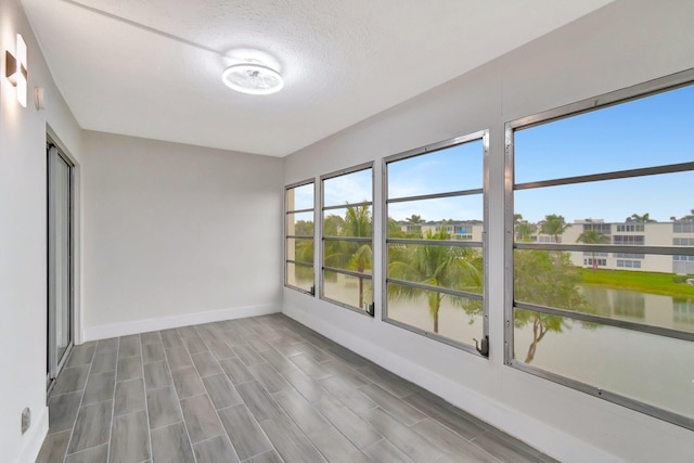 unfurnished sunroom with a water view