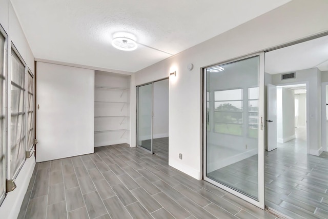 empty room with a barn door and a textured ceiling