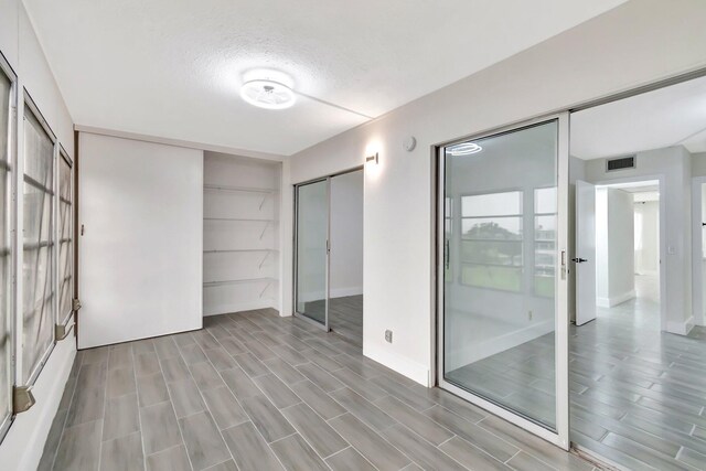 interior space featuring wood tiled floor, visible vents, and a textured ceiling