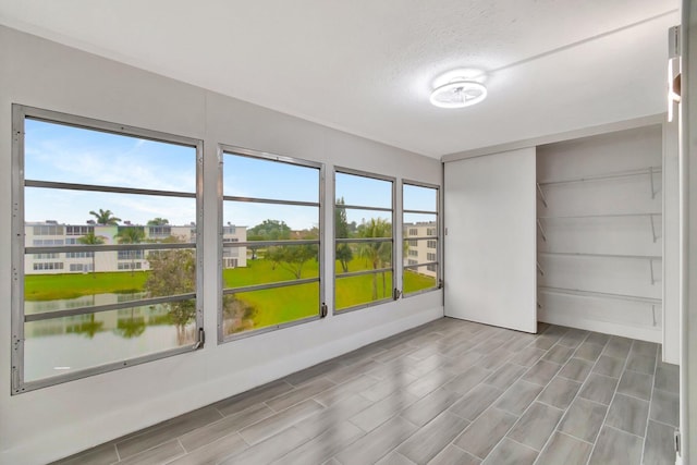 empty room featuring a water view and a textured ceiling