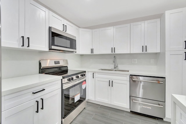 kitchen featuring white cabinetry, sink, and appliances with stainless steel finishes