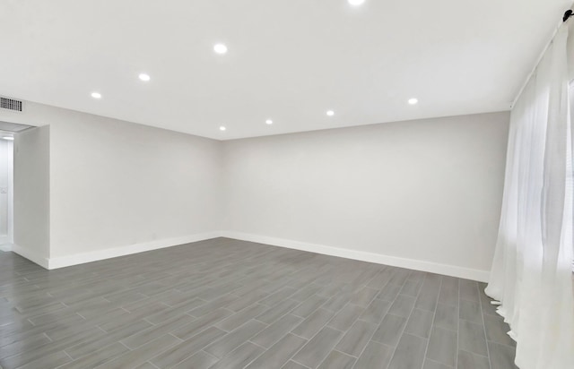 unfurnished room featuring baseboards, visible vents, recessed lighting, and wood finished floors