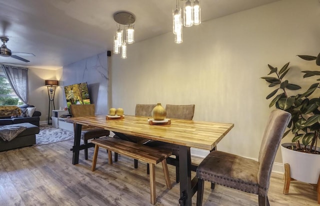 dining space featuring ceiling fan, baseboards, and wood finished floors