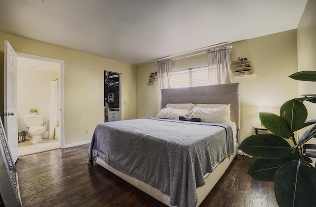 bedroom with baseboards, connected bathroom, and hardwood / wood-style floors