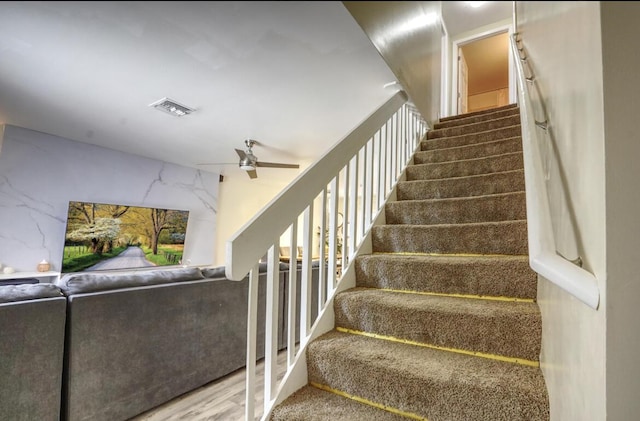 staircase with visible vents and a ceiling fan