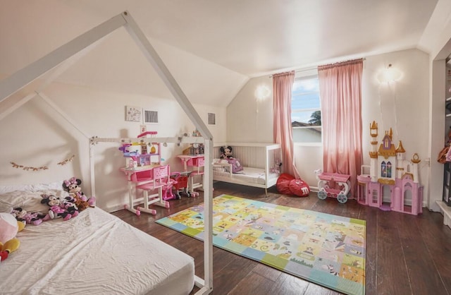 bedroom with vaulted ceiling, visible vents, and hardwood / wood-style flooring