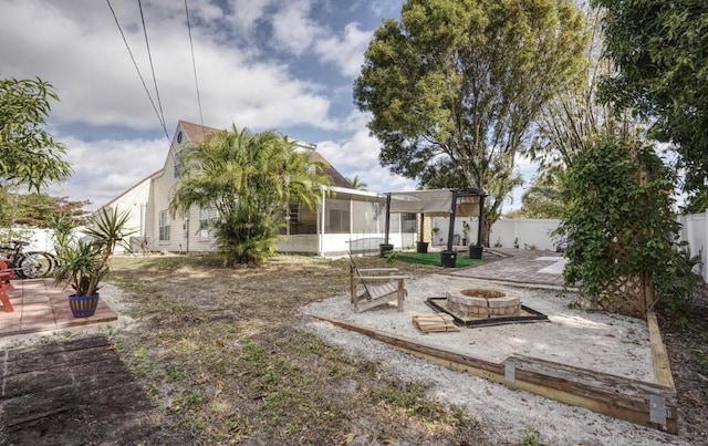 back of house with a fire pit, a sunroom, a fenced backyard, a patio area, and a pergola