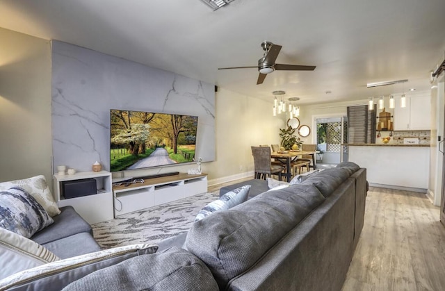 living room featuring a ceiling fan and light wood-style flooring