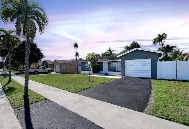 single story home featuring a yard and a garage