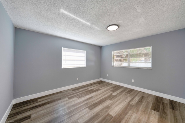 spare room featuring a textured ceiling and hardwood / wood-style flooring