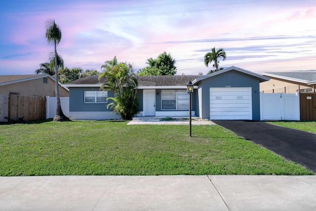 single story home featuring a yard and a garage