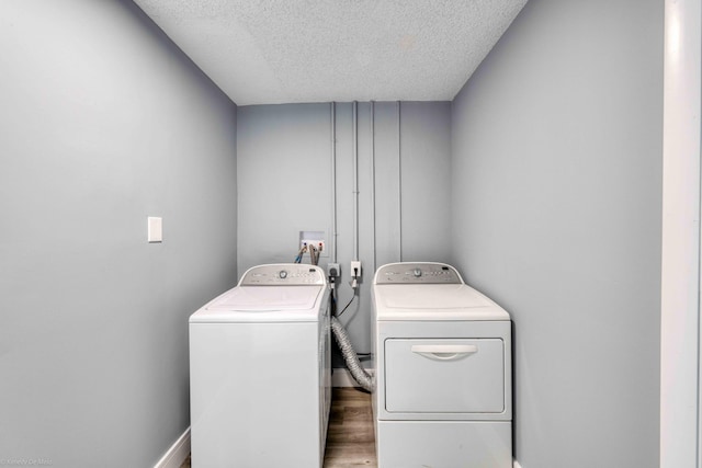 clothes washing area with separate washer and dryer, dark hardwood / wood-style flooring, and a textured ceiling