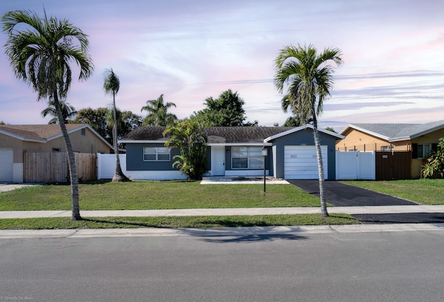 ranch-style house featuring a yard and a garage