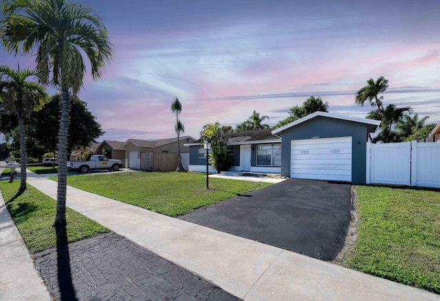 single story home with a yard and a garage