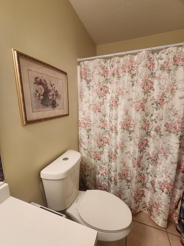 bathroom featuring tile patterned flooring, toilet, and a textured ceiling