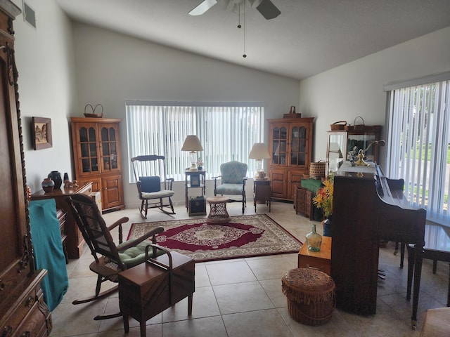 tiled living room with vaulted ceiling, ceiling fan, and a healthy amount of sunlight