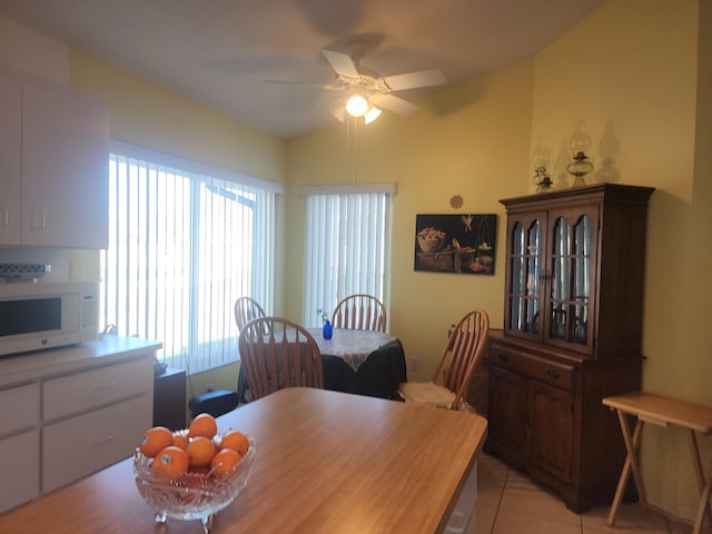 dining area featuring light tile patterned floors, plenty of natural light, lofted ceiling, and ceiling fan