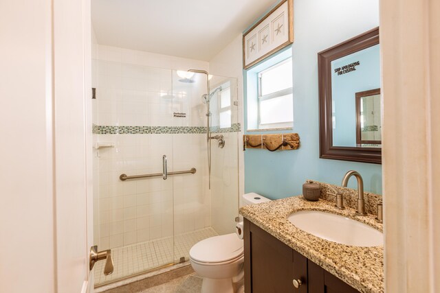 full bath featuring a stall shower, toilet, and vanity