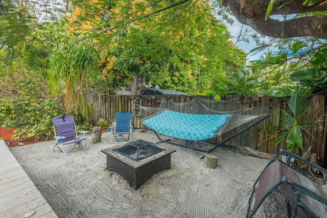 view of patio featuring fence and a fire pit