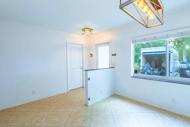 spare room with a notable chandelier