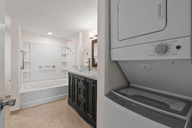 washroom with stacked washer and dryer, light tile patterned flooring, and sink