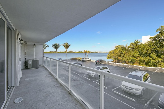 balcony with central AC unit and a water view